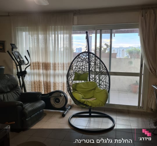 תריסים לבנים על חלון זכוכית בסלון מואר